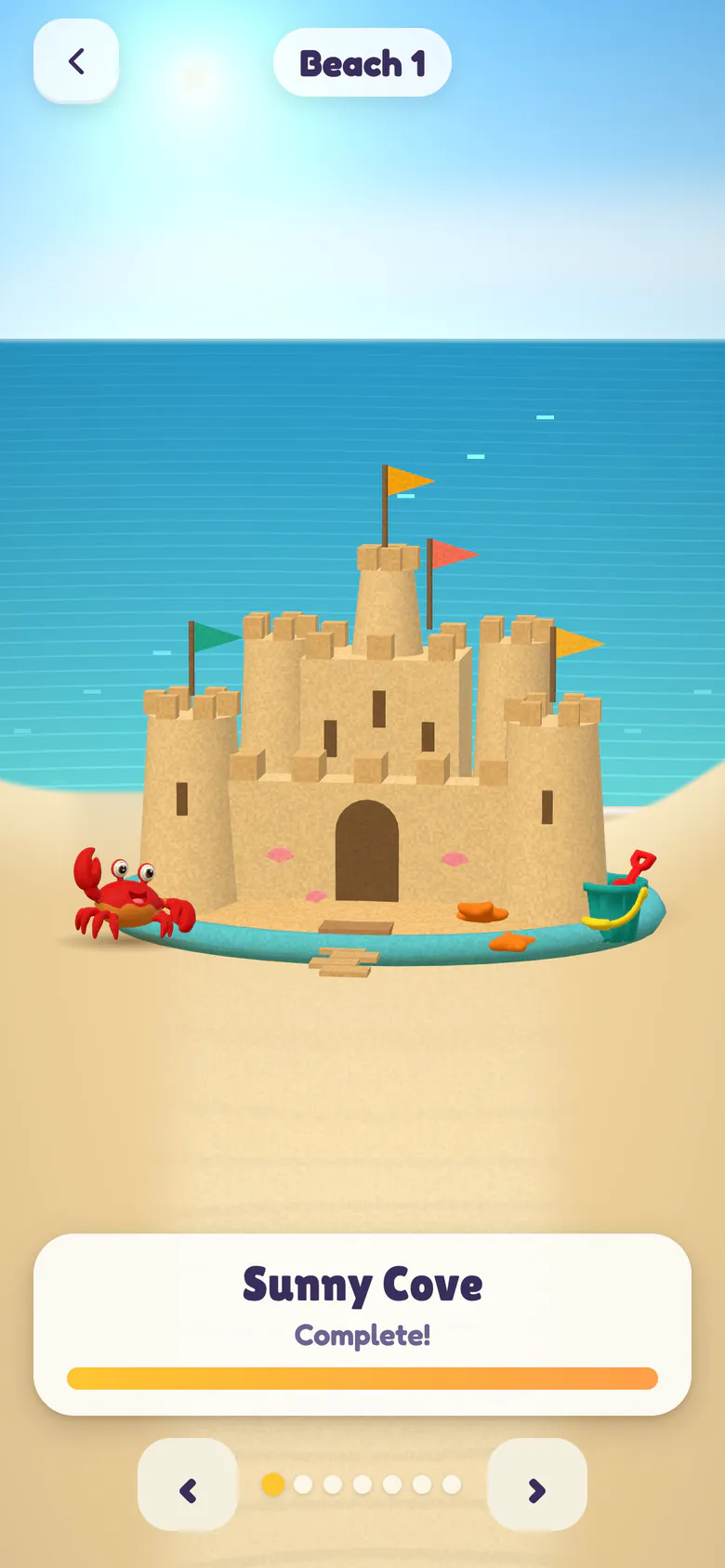 The Castles screen: the finished Sunny Cove sandcastle with towers, battlements, four flags and a moat, a red crab and a bucket and spade beside it, and the Complete! progress bar.