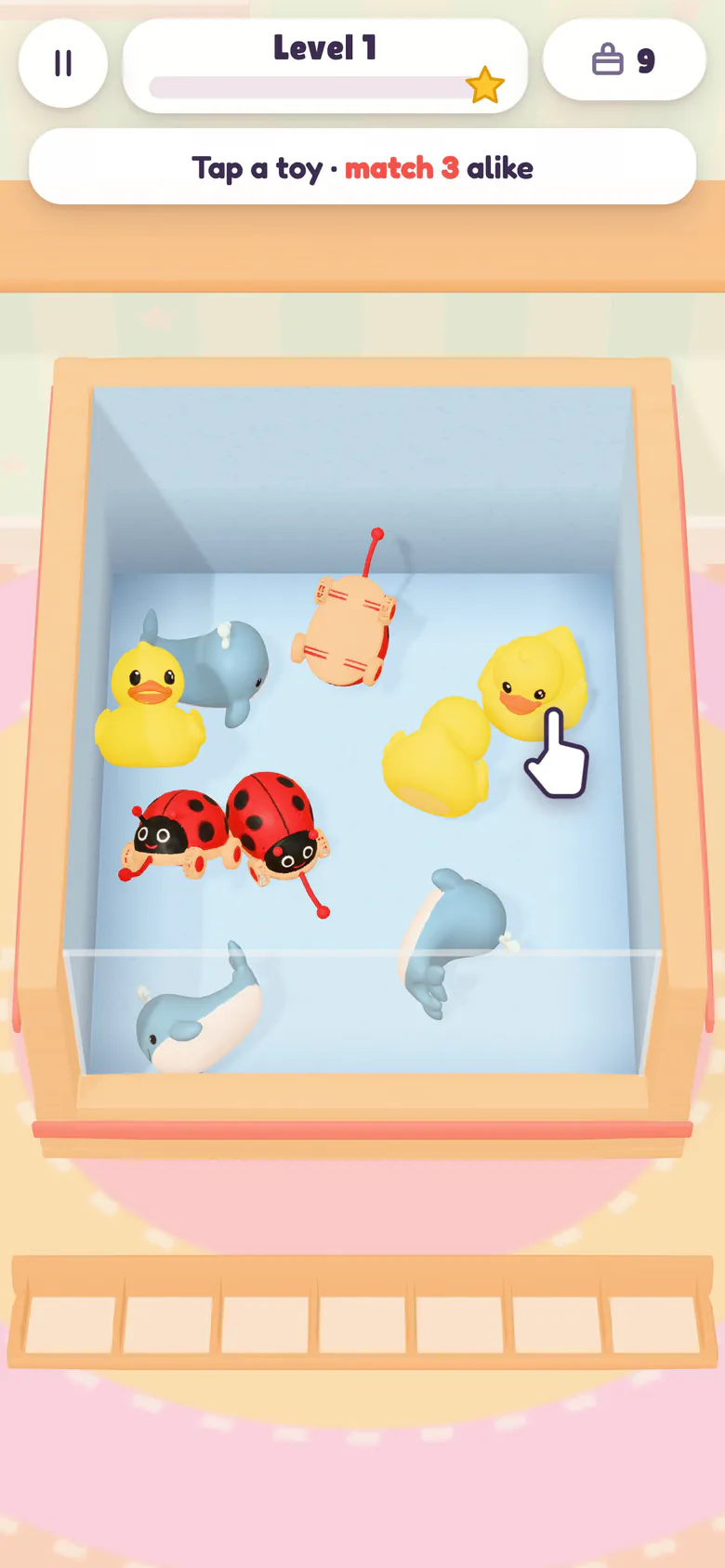 Level 1: big rubber ducks, ladybugs and whales in a blue-lined toy chest, a pointing hand on a duck and the hint Tap a toy · match 3 alike, with the empty seven-slot tray below.