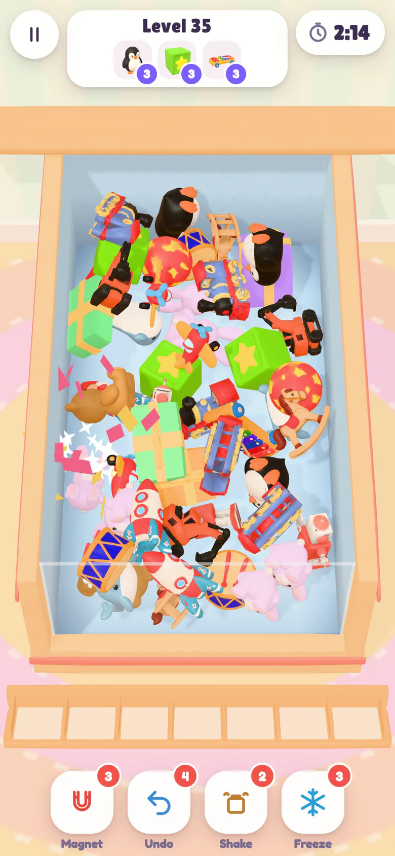 Level 35: a pink gift box bursts open in a shower of paper to reveal a plush bunny while a green gift waits in the heap, with the goal toys to collect (penguins, star blocks and airplanes) shown at the top.