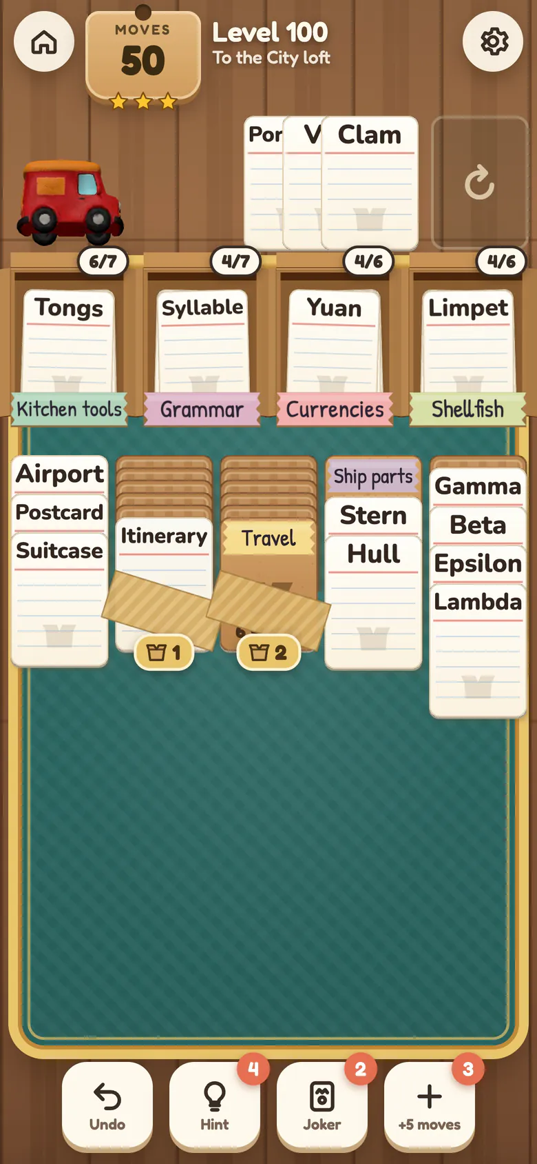 Level 100: four open crates labelled Kitchen tools, Grammar, Currencies and Shellfish with packed words inside, five columns of word cards with stacks such as Gamma, Beta, Epsilon and Lambda, two columns under packing tape, the stock and a fan of dealt cards.